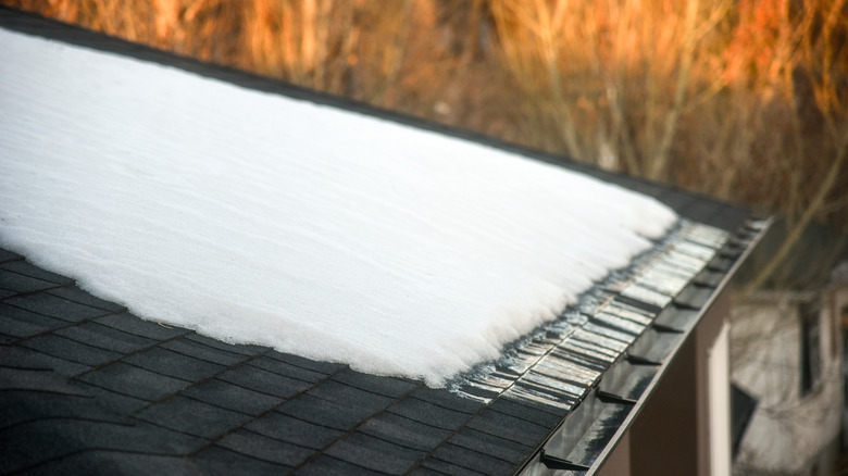 Snow melts on shingle roof