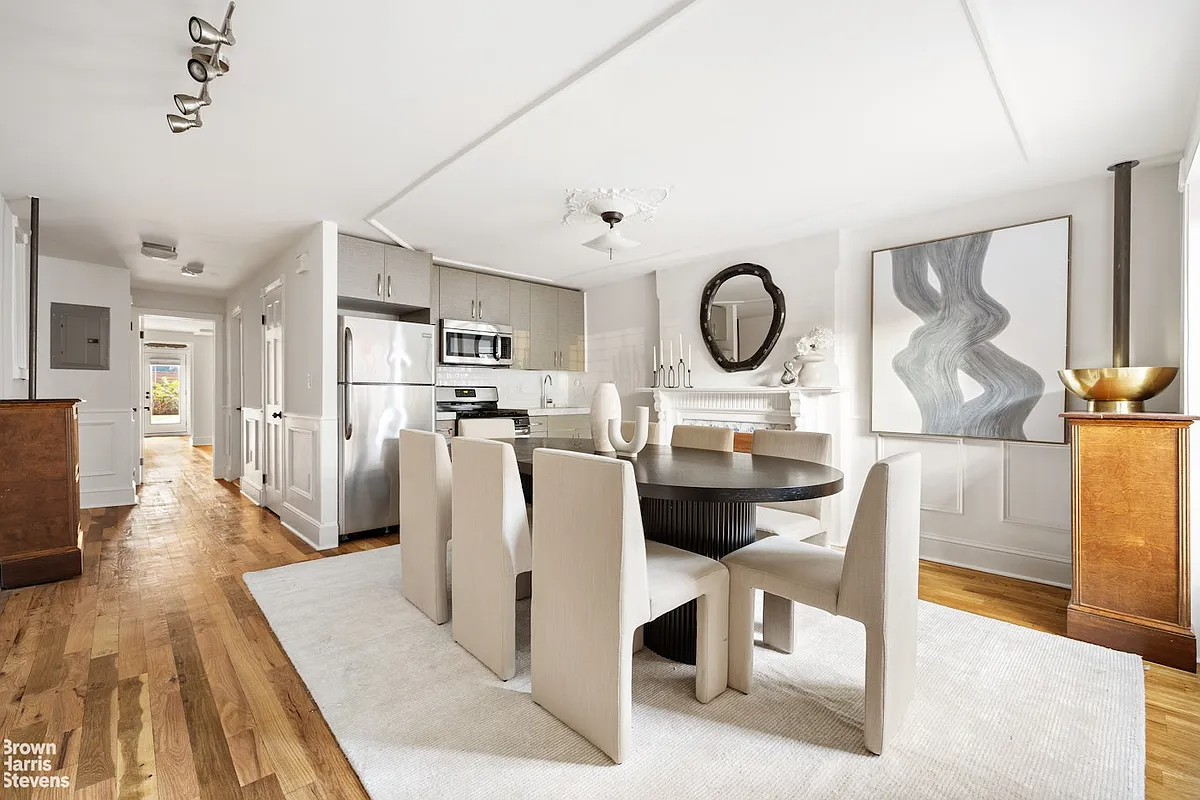 Garden level dining area and small kitchen with white walls and wooden floor