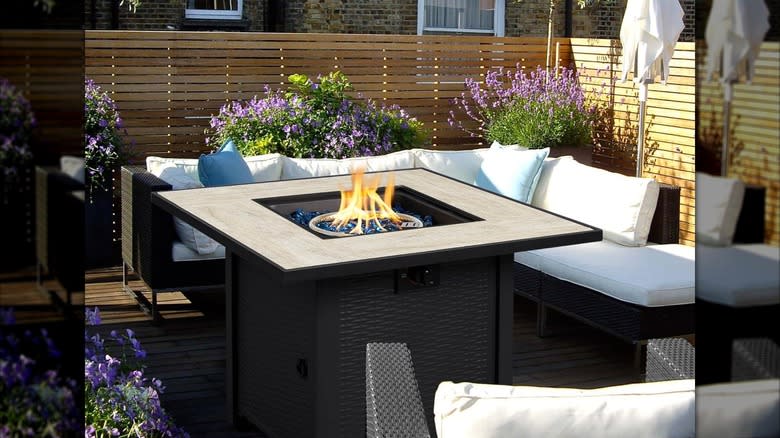 A large smoke-free fire pit is surrounded by luxurious patio furniture