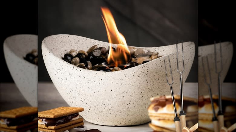 A smokeless concrete fire pit is surrounded by s'mores ingredients