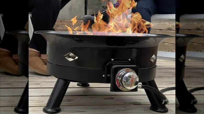 A smokeless fire pit from Flame King sits on a wooden deck