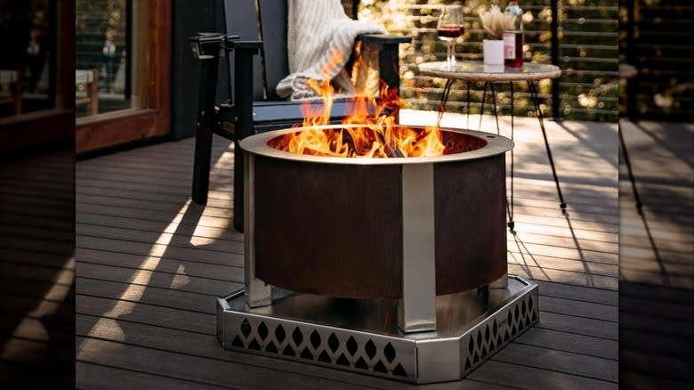 A smokeless fire pit from Breeo sits on a patio next to a table and chair