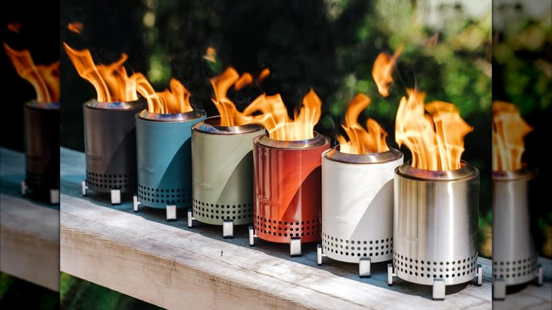 Several Solo Stoves are displayed on a wooden bench