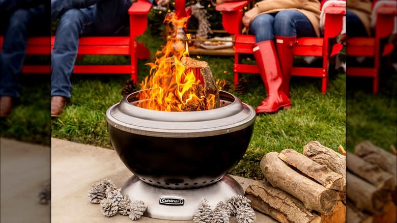 Two people sit on red chairs near a Cusinart smokeless fire pit