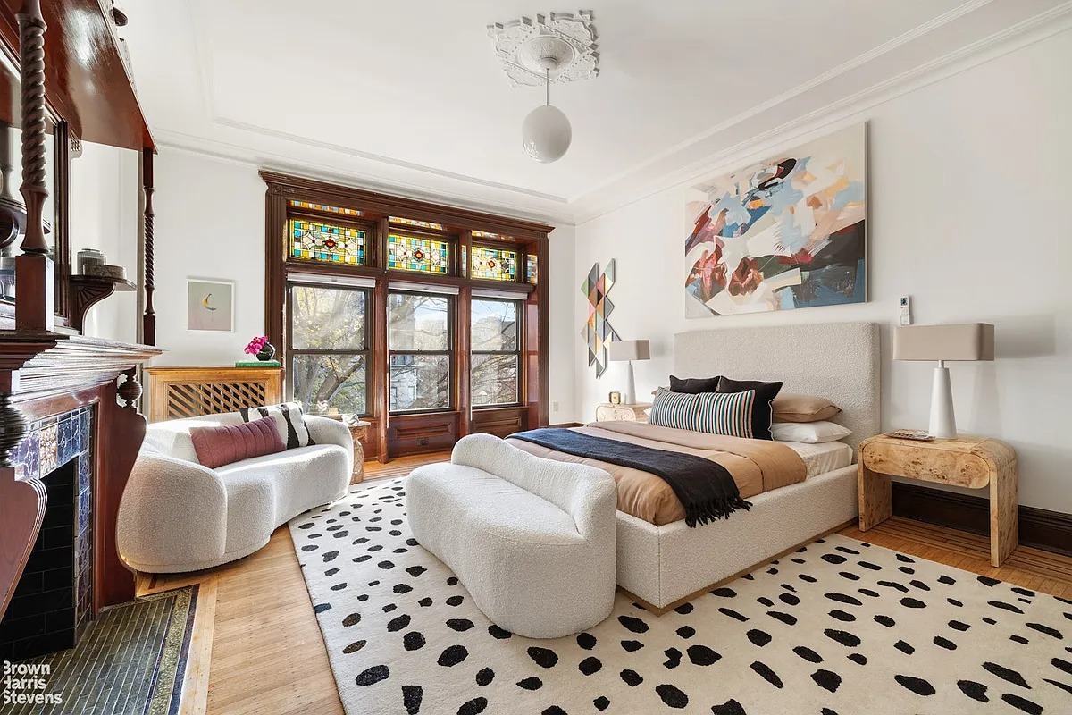 Bedroom with wooden floors, fireplace mantel and ceiling medallion