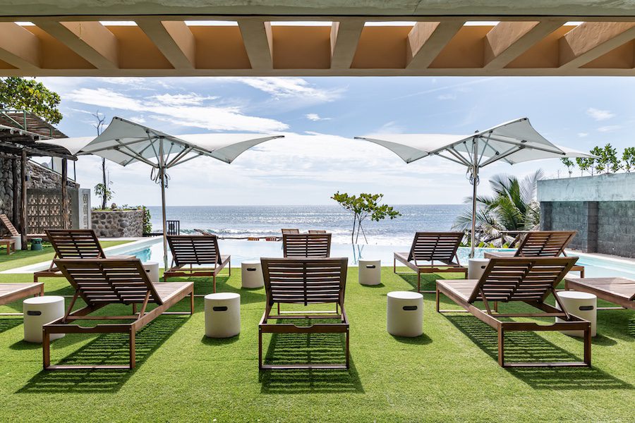 Wave house El Zonte El Salvador surf town natural palette grass outdoor terrace sunbeds sea view