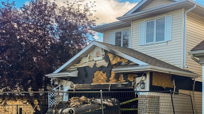 The garage of a yellow house is fire damaged