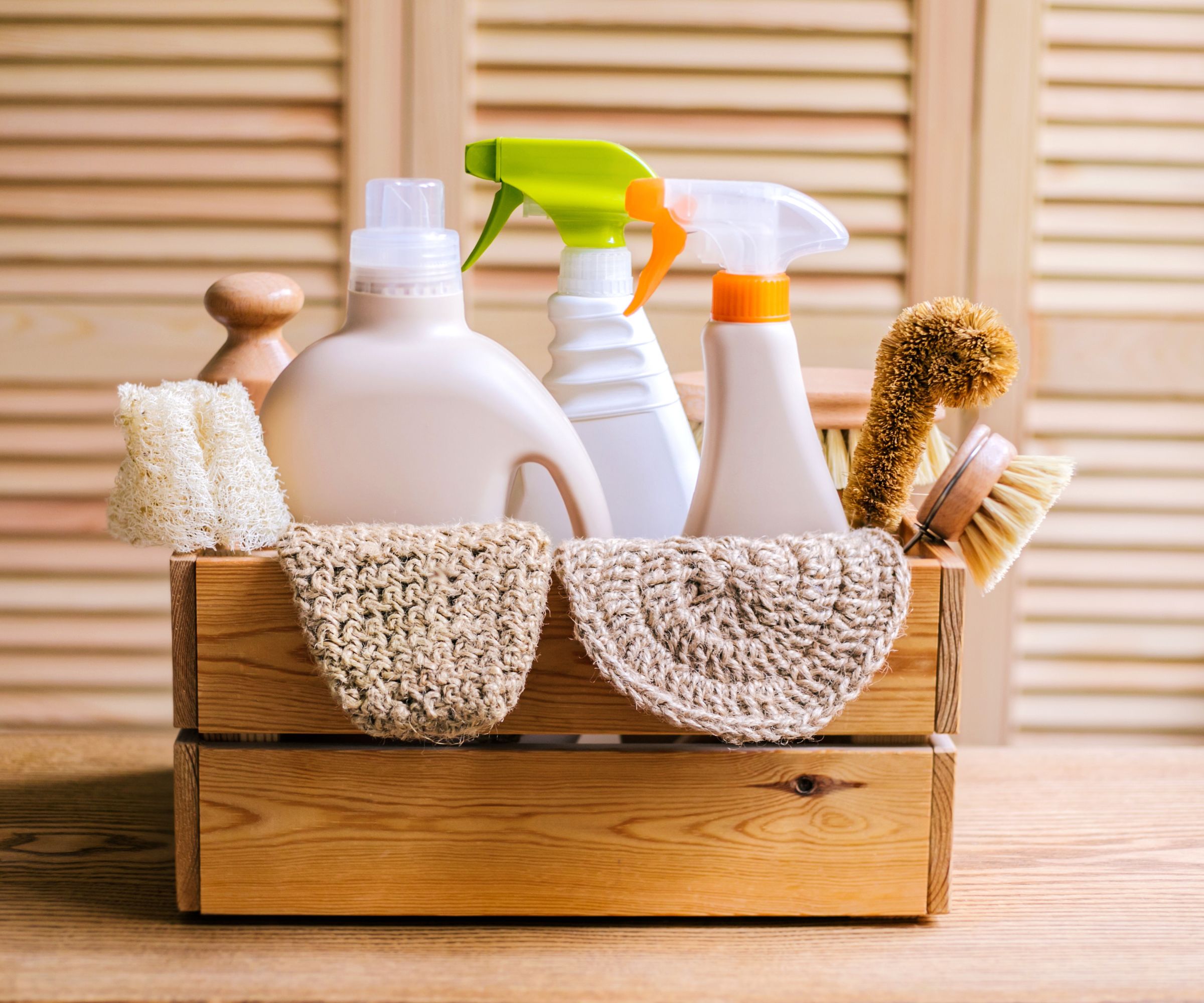 A wooden box filled with unbranded cleaning spray bottles