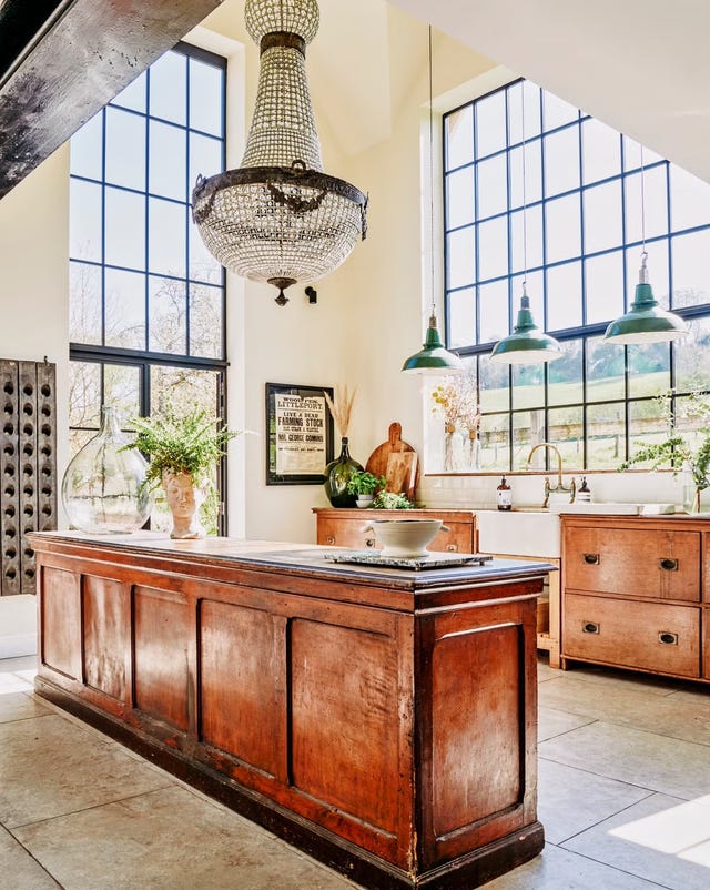 The kitchen presents a large wooden island with a polished finish, complemented by a decorative bowl in the center