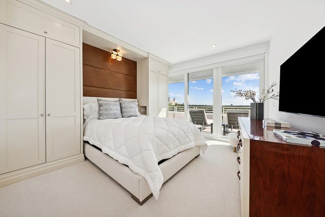 The bed in one of the guest suites is built into a niche that is generated by built -in cupboards on the wall.