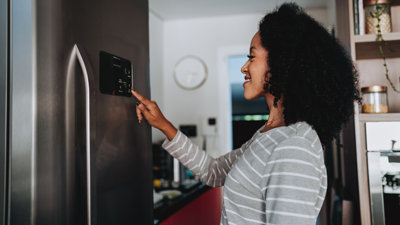 Woman who uses a touchscreen console on her intelligent fridge