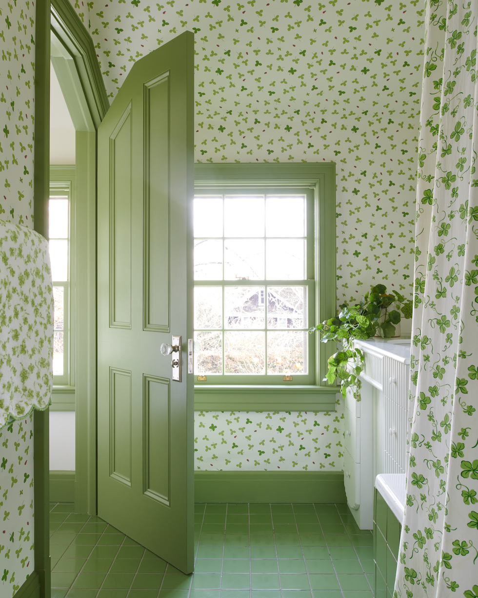 A clover printing wall cover in a bathroom with green tiles