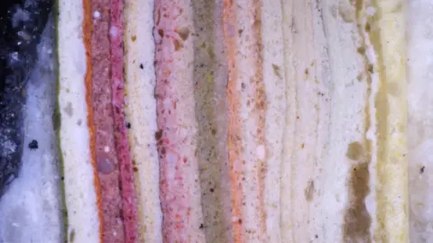 York City Council enlarged the image of different layers of paint and shows red, white, orange and green.