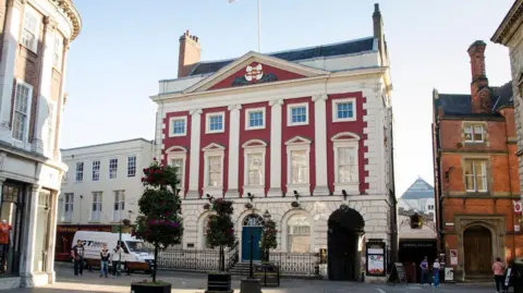 Getty forms the exterior of a white and red Georgian building on a city square.