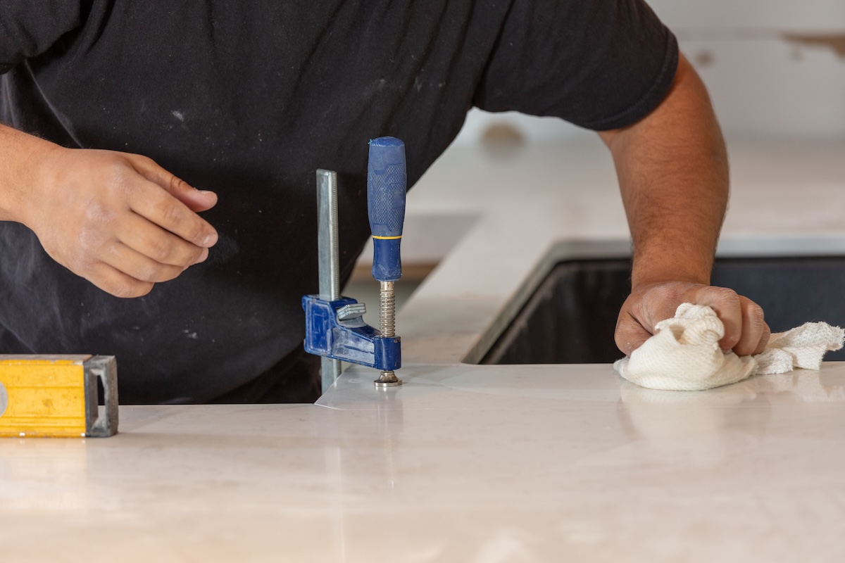 An contractor who installs a white quartz worktop in a small kitchen conversion.