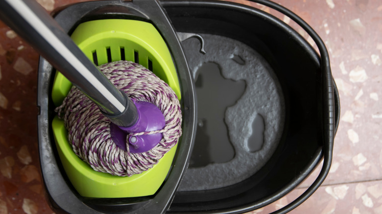 A bucket and a MOP on TerrazzP tile floors.