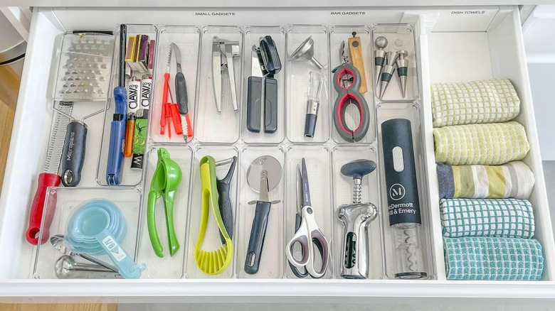 Well organized kitchen island of drawers with devices and kitchen towels in the warehouse organizer