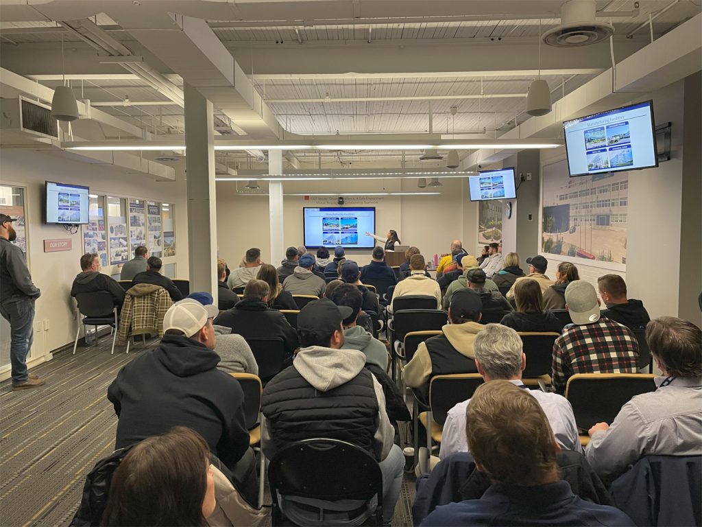 The participants sat in a presentation room in a presentation room during the CGT dealer day, look at a speaker and show screens.