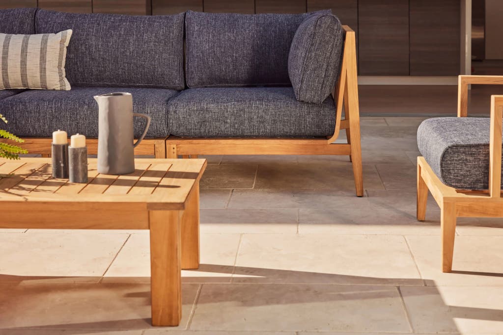 An external teaker -outdoor sofa and chair in an outdoor environment.