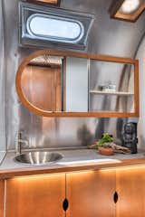 The bathroom has a spacious worktop and an asymmetrical mirror.