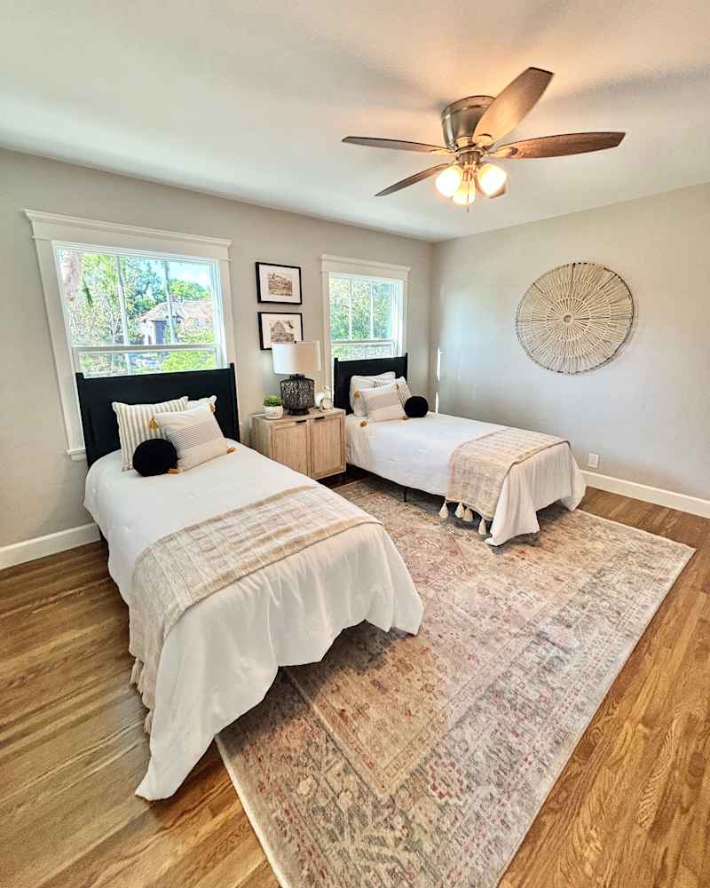 Two two beds in neutral tinted, staged bedroom.