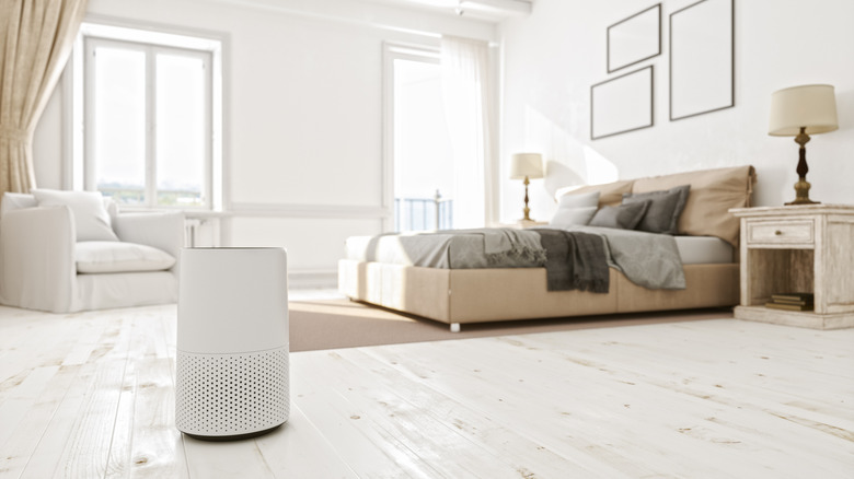 An air purifier in a bedroom with white walls