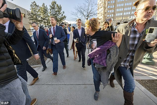 Chystina Page, right, holds back Heather de Wolf when after a hearing in February 2024 in Colorado Springs, Colorado, with his lawyers after a hearing in February 2024 in Colorado, Colorado, in Jon Hallford, left, the owner of Back to Nature Funeral Home