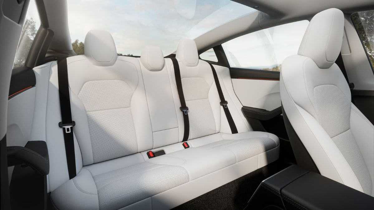 Pristine white leather seats with perforated texture, black safety belt, slim modern interior with panoramic view
