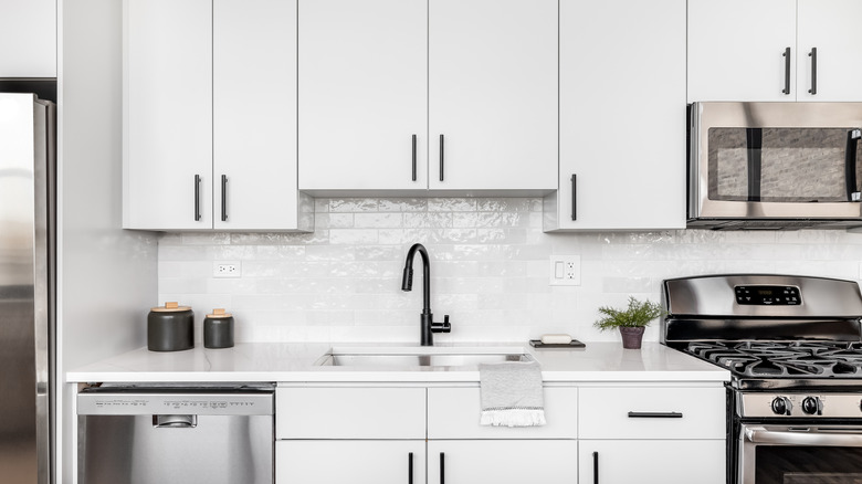 White kitchen cabinets with black handles