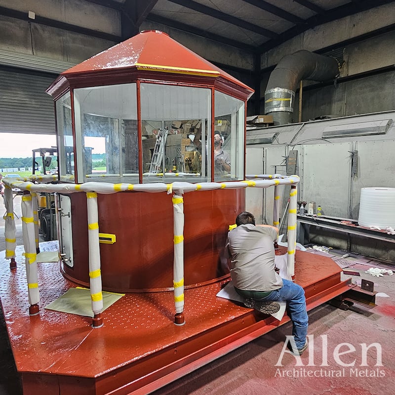 A worker is shown when working on the newly painted lantern