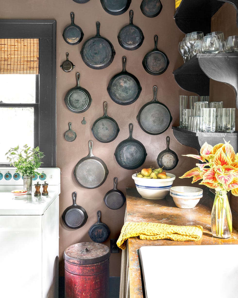 Collection of vintage cast iron pans hang on the wall Collection of Vintage -Gussisen pans that hang on the wall