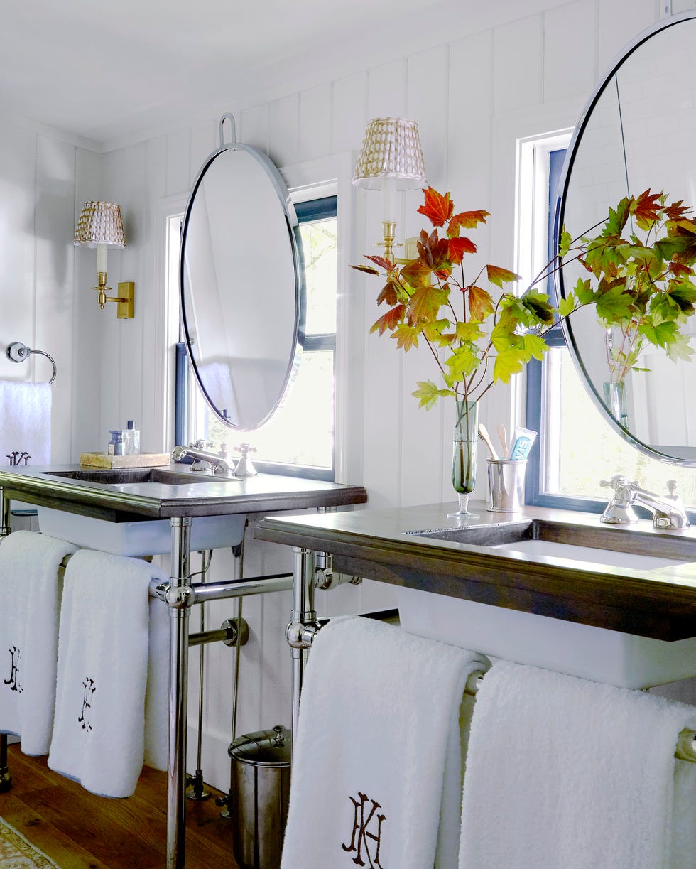 Primary bathroom with two free -standing sinks and mirrors on the windows over each