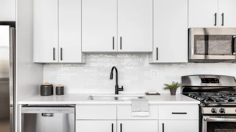 White kitchen cabinets with black handles