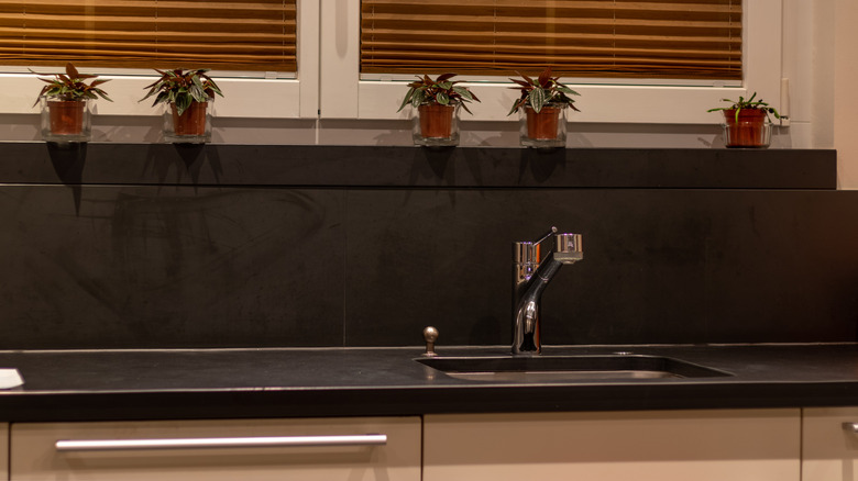 Sink with a black plate worktop and back splash