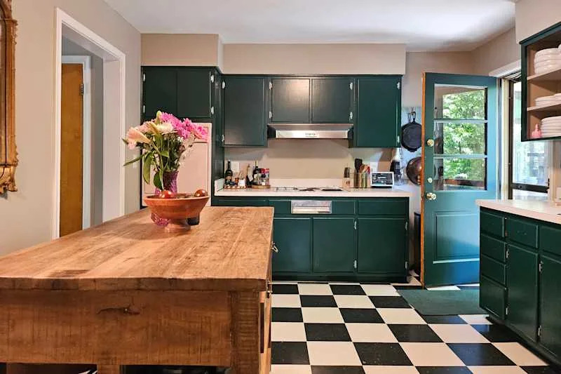 Green painted cupboards in slowly decorated kitchen.