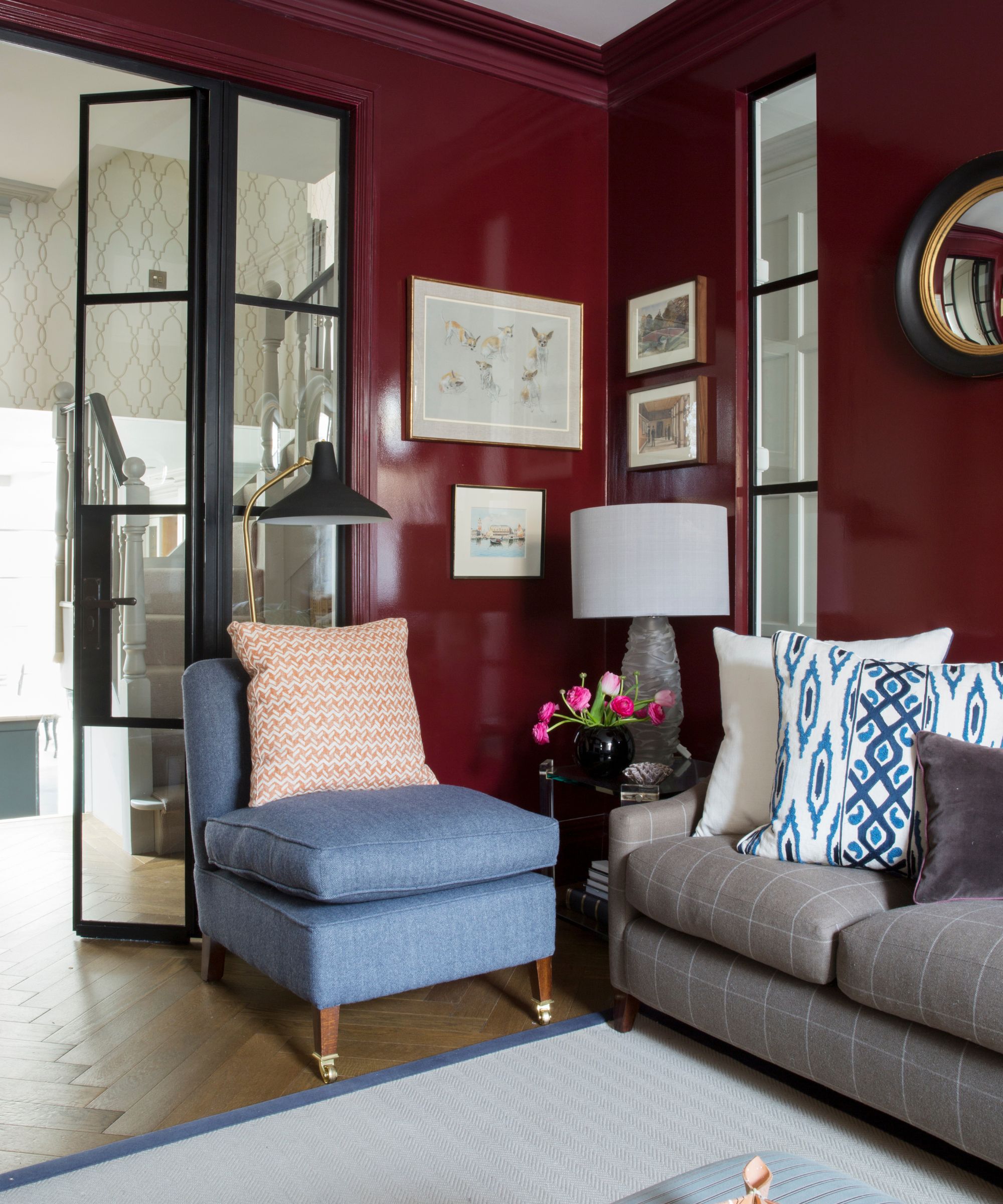 Living room in a shiny red with modern black double doors that lead to the connecting room
