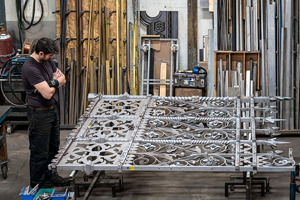 A Heritage Metal restoration Professional inspects part of the main queen of the main queen in the Montreal Workshop of Dominion Restoration.