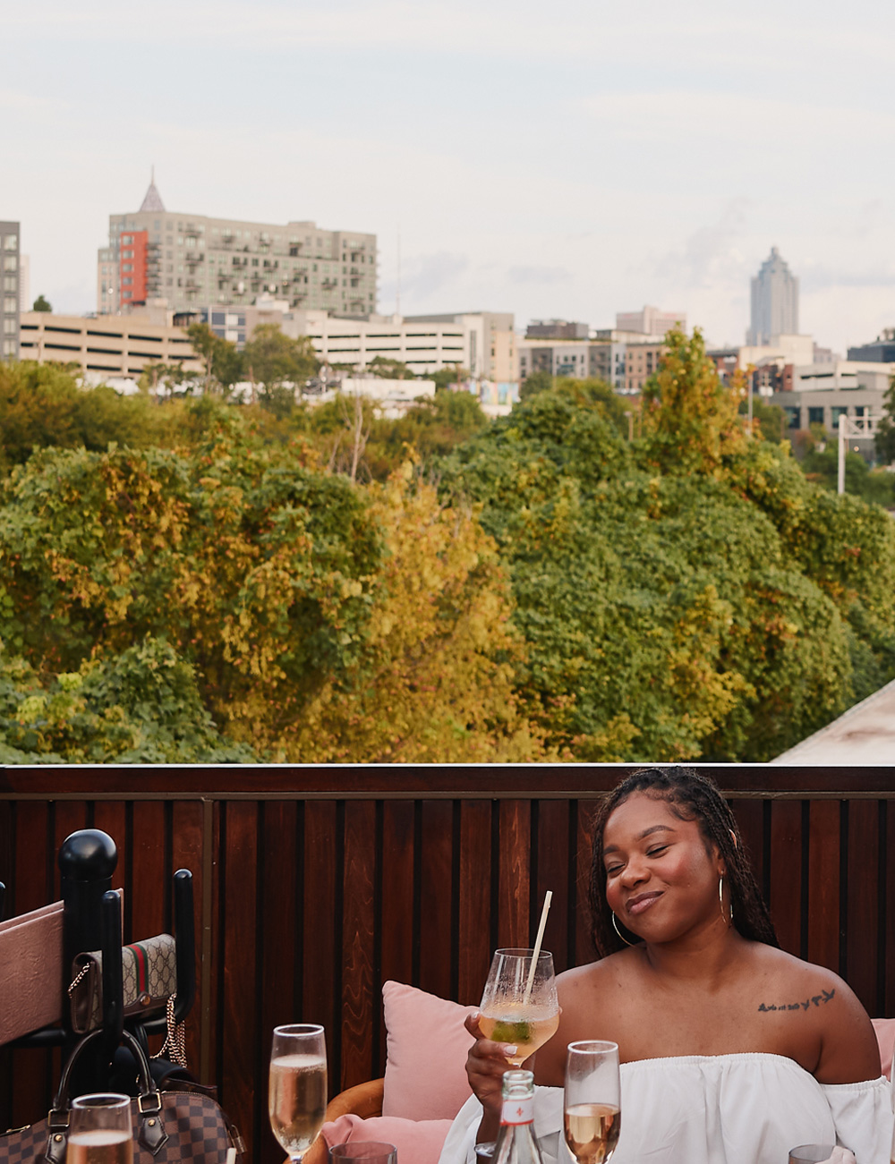 Skyline and treetop views mingle with a sunkissed cocktail