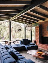 While the property was sold as a teardown to Mary Blodgett and Carlton Calvin, the couple realized its potential. "It fell apart, but beautiful," Mary remembers. "I'm a preservationist when I can be." In the living room of the main house, a sofa by Patricia Urquiola surrounds a coffee table by Nathan Young, at the end of which is a floor lamp by Achille Castiglioni.