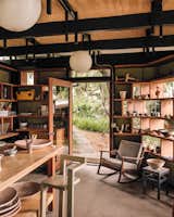 The ceramics studio's enclosure consists of a roof that extends above the original rafters and glazing mounted directly on shelves suspended between the original columns.