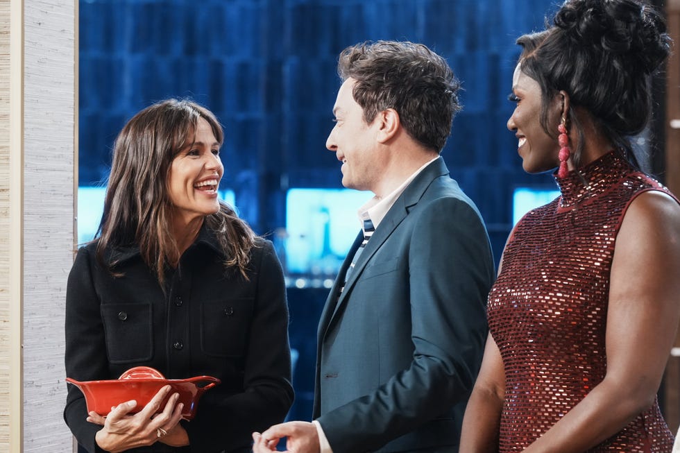 Three people have a conversation in a modern setting, with the focus on a dish.