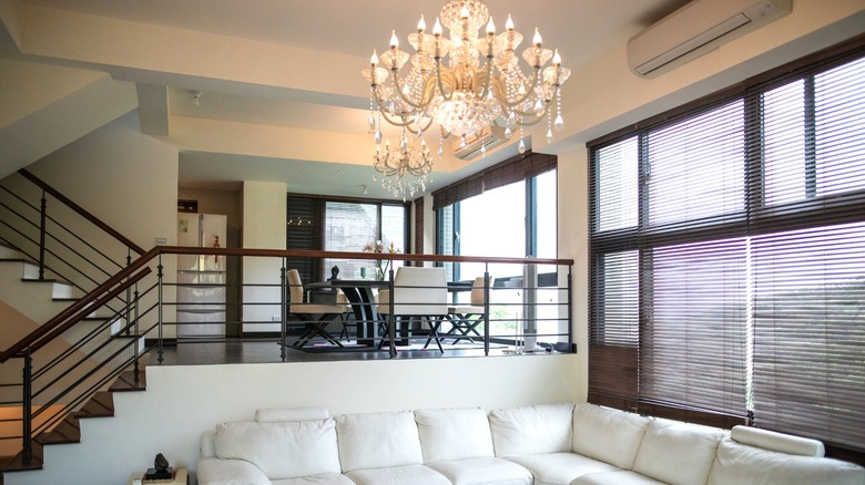 Chandelier above white leather sofa in modern living room