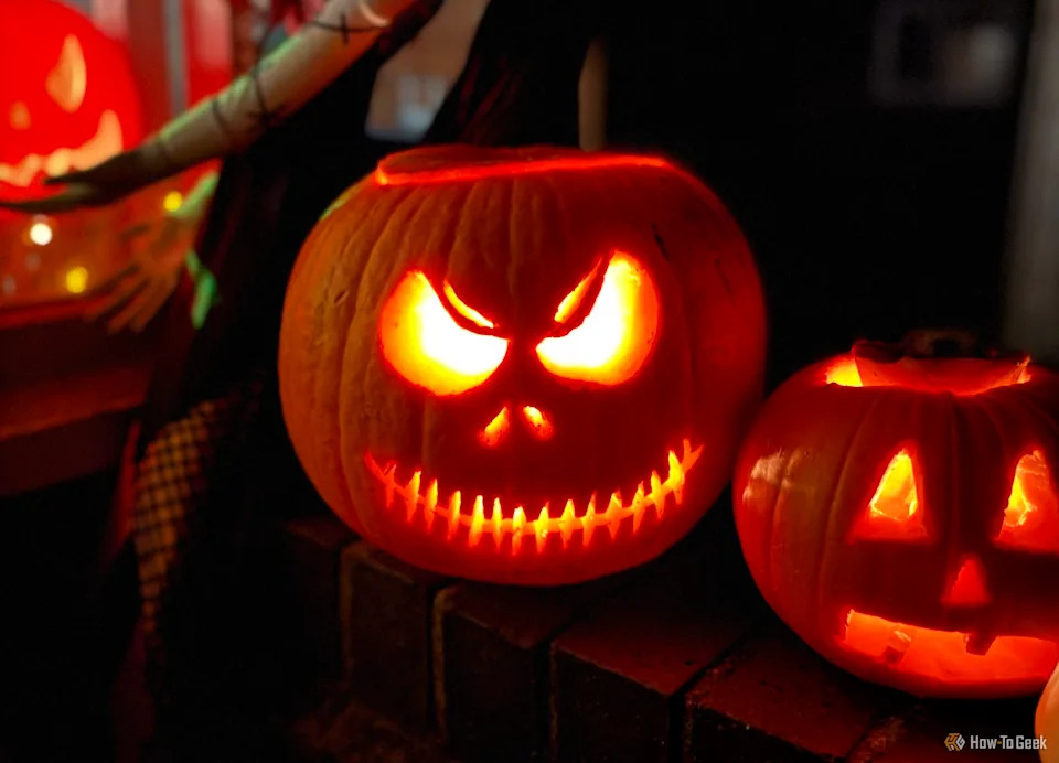 Spooky jack-o-lanterns in front of a house on Halloween.