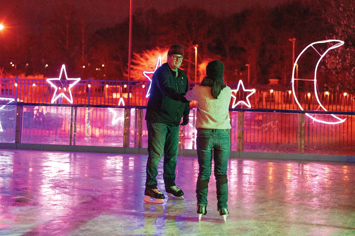Guests can ice skate at Ice and Lights in Cameron Run Park, surrounded by festive light displays.